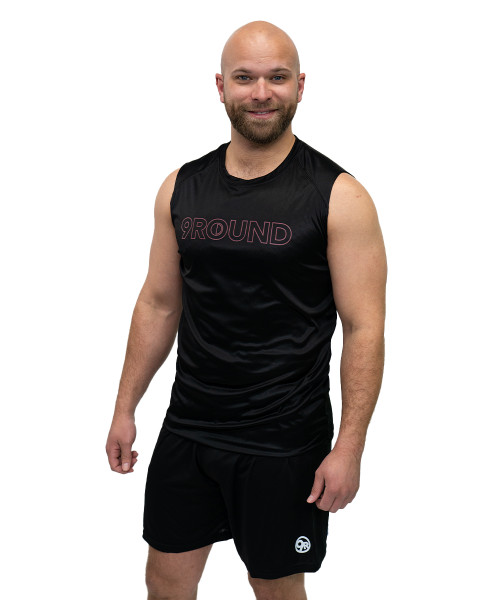 A man with a shaved head and beard wears a sleeveless black 9ROUND shirt and black shorts, standing against a white background.