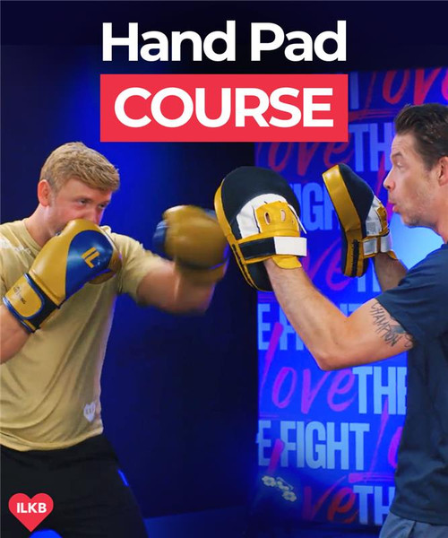 Two men practice boxing techniques using hand pads in a gym. The text above them reads Hand Pad Course.