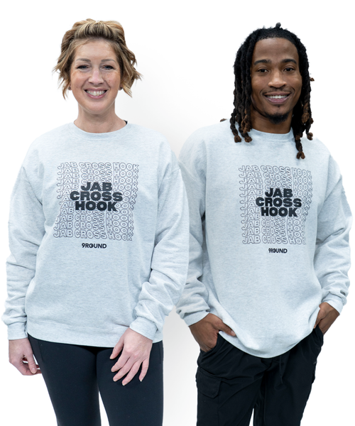 Two people wearing light gray sweatshirts with JAB CROSS HOOK and 9ROUND printed on the front, standing against a plain white background.