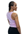 A side profile of a woman wearing a pink cropped tank top and black leggings