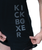 A black shirt with the word kickboxer stacked in a graphic design in grey font with a woman stretching the fabric around this to make it easier to read