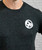 A close up of the front of a black sweater with a white 9Round circle logo on the upper right-hand side