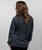 A back view of a woman wearing a long-sleeve black and grey acid wash t-shirt