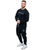 A full-body image of a young adult male wearing a black sweatshirt and black joggers with 9Round outline logos