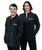 A man and woman posing together in the same black fleece zip-up jacket with a white 9Round logo on the right-hand side of the upper chest area