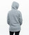 The back of a adult wearing a grey hoodie with the hood up