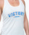 A close up view of a white tank top that reads Victory in the center in a white and blue star print, followed by the 9Round logo with two stars on either side.