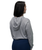 A person wearing a gray hooded long-sleeve top and dark blue pants is standing with their back facing the camera against a white background.