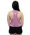 A person with long dark hair is standing with their back to the camera, wearing a pink racerback tank top and black shorts.