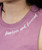 Close-up of a person wearing a pink sleeveless top with the words fearless and focused printed in white script near the neckline.