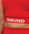 Close-up of a person wearing a red sports top with the word 9ROUND printed on the band below the chest.