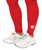 A person wearing red athletic leggings and white Nike sneakers standing on a white background.