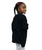 Young girl with braided hair and red hair ties wearing an oversized black T-shirt and gray pants, standing and looking over her shoulder against a white background.
