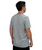 A man with short brown hair is standing and facing away, wearing a plain gray short-sleeve t-shirt and black shorts against a white background.