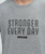 Gray t-shirt with the text STRONGER EVERY DAY 9ROUND printed in black on the front.