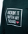 Dark green shirt with white block text that reads Kickin It With My Squad and a small red heart labeled ILKB on the front.