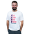 A smiling man with a beard wearing a white t-shirt that says Eat, Sleep, Kick, Repeat. I Love Kickboxing, with checked boxes next to each phrase.
