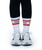 A person wearing black leggings, white athletic shoes, and white socks with red 9ROUND text stands on a white background.