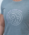 Person wearing a grey t-shirt with the text STRONGER WITH EVERY KICK and a circular logo featuring 9R on the front.
