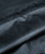 Close-up of the black mesh drawstring bag with a visible seam and a slightly shiny surface.