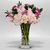 is a soft and elegant floral arrangement featuring blush hydrangeas, pink roses, and fresh greenery, arranged in a clear glass vase