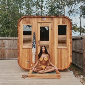 Women Meditating Outside of Her Cedar Cube Sauna