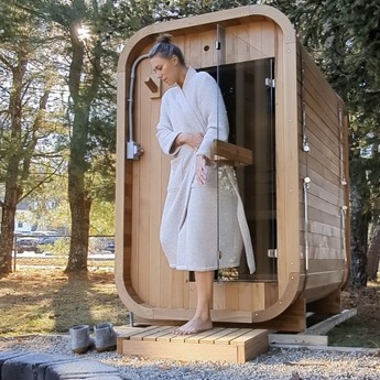 Women using the mini cube sauna outdoors