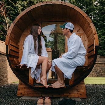 Man and woman enjoying the porch on their Redwood Outdoors sauna