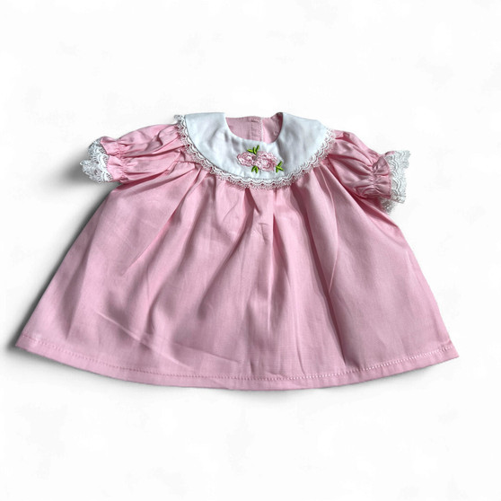 Ann Lauren Dolls® pink embroidered dress fits 18-inch baby dolls. Features a white Peter Pan collar with floral embroidery, lace trim, and puff sleeves.