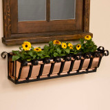 Pacific Heights Copper Window Box with yellow flowers mounted under a wood trimmed window