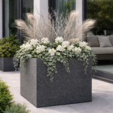 Strato Fiberstone Planter in Zinc finish  on a patio with white flowers and trailing ivy