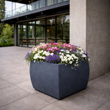 Kahn Rectangular Fiberstone Planter in zinc finish planted with flowers on back patio of contemporary home
