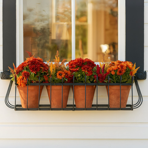 Heatherbrook window box mounted under a window with terracotta pots planted with fall flowers