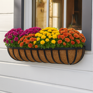 English garden hayrack mounted below a window with fall colored flowers English garden hayrack mounted below a window with fall colored flowers