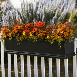 Black Laguna Railing Planter on white wood fence planted with fall foliage with lavender in background