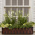 Arch window box with bronze liner mounted under a window on a white home