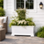 Laguna Footed Deck Planter with small trellis and white flowers in front of a home