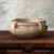 Etruscan bowl shown in antigua on wood table with gray background