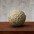 String sphere in Tiza Finish on wood table with gray background