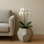 Dodeca Planter in Chenza planted with white orchids next to a sofa