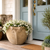 Rangoon Planter in Antigua finish on a front porch by a light blue front door