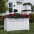 Coronado PVC Rectangle Planter planted with magenta flowers on grass area in front of a home