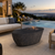 Boulder fire table shown in terron near a pool with city views in background