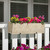 Jaadar fiberstone railing planter  in Antigua finish with yellow red and pink flowers