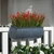 Barrel Fiberstone Railing Planter in zinc finish with red flowers on a white railing
