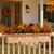 Newport Cedar railing planter on  a wood railing with fall flowers with a porch in background
