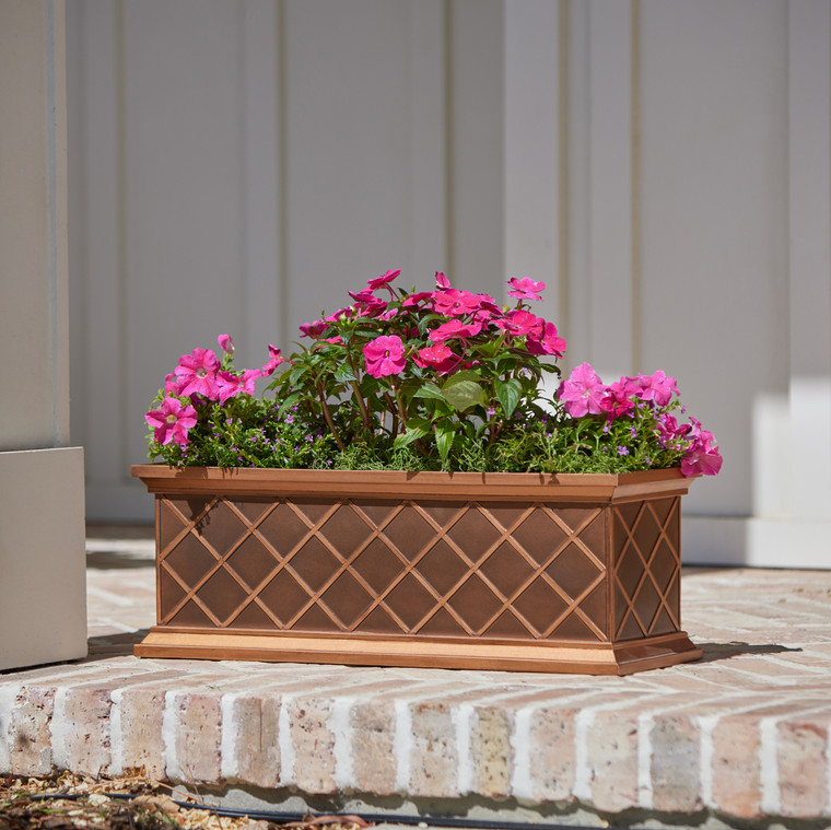 Copper ArmoreCoat La Fleur Window Box with hot pink flowers on a used brick porch