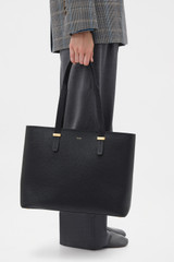 Profile view of model wearing the Oroton Anika 15" Tote & Cover in Black and Premium pebble leather for Women .