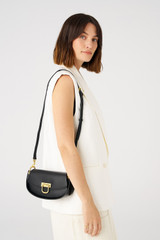 Profile view of model wearing the Oroton Colt Small Baguette in Black and Smooth leather for Women .