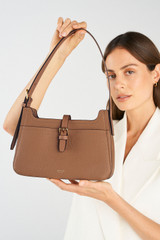 Profile view of model wearing the Oroton Dylan Baguette in Tan and Pebble Leather for Women .